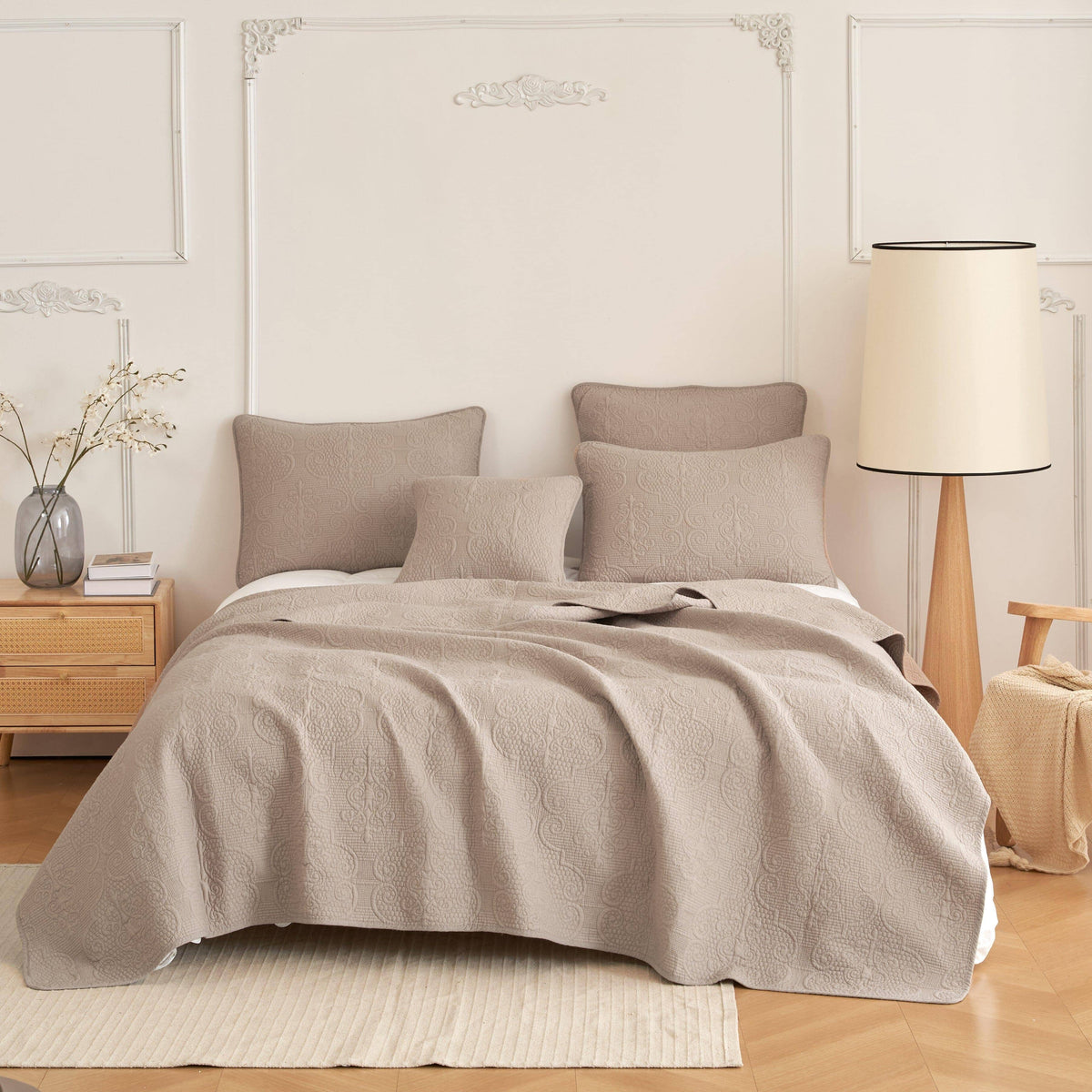 Taupe quilt and coordinated pillows in a softly styled guest bedroom