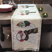 Decorative table runner with snowman design on a wooden table.