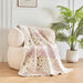 DaDalogy Cotton Patchwork Throw Blanket on a cozy chair, featuring floral designs in blush pink and cream.