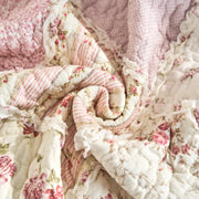 Close-up of DaDalogy Cotton Patchwork Throw Blanket in floral design with blush pink and cream ruffles, showcasing vintage charm.