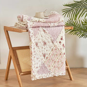 DaDalogy Cotton Patchwork Throw Blanket in blush pink and cream on a wooden rack, showcasing shabby chic floral design.