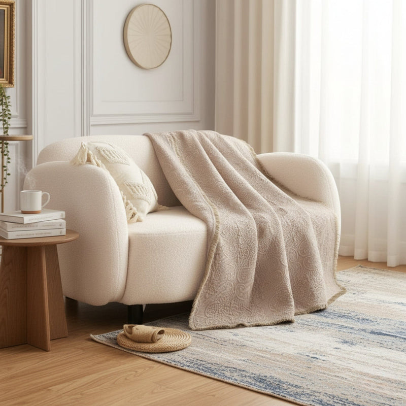 Beige blanket draped over a white armchair in a bright living room.
