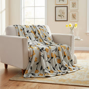 Floral-patterned blanket draped over a white armchair in a living room.