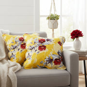 Yellow floral cushions on a gray sofa with a bright room setting