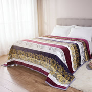 Decorative floral-patterned quilt on a bed in a bedroom setting