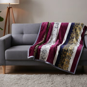 Gray sofa with a decorative burgundy blanket featuring gold and white patterns.