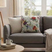 Gray sofa with floral pillow and coffee on a small table in a bright living room.
