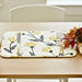 Floral-patterned placemat with knife, fork, and decorative elements on a table.