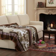 Cozy living room with a beige sofa, patterned flannel mink blanket, and a fireplace.
