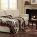 Cozy living room with a beige sofa, patterned flannel mink blanket, and a fireplace.
