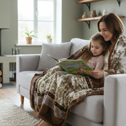 Woman and child reading a book together on a couch in a cozy living room under a cozy mink blanket that is perfect for gift.