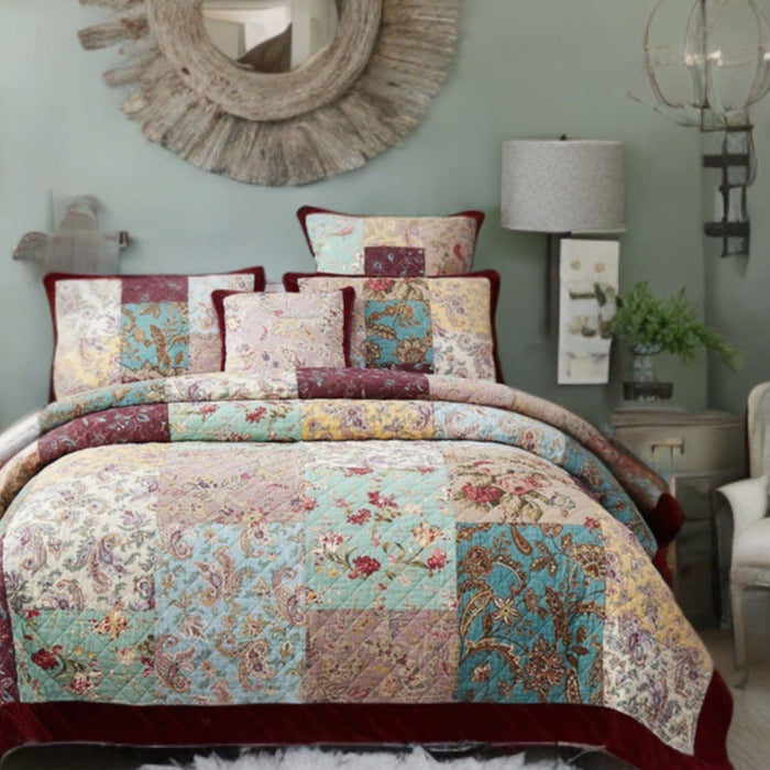 Patchwork quilt bedding. A burgundy floral bedspread