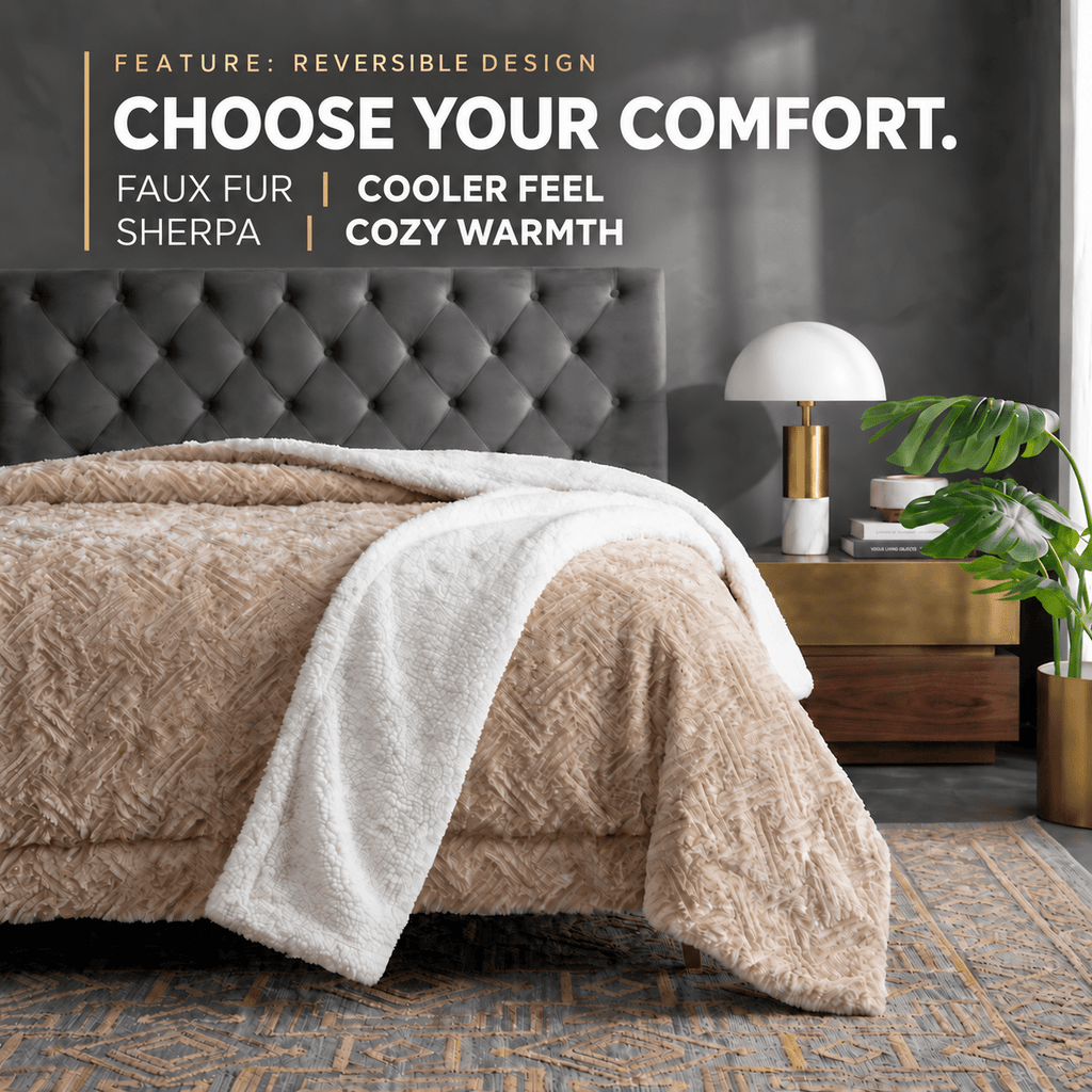 A cozy bedroom scene showing a bed dressed in a reversible textured blanket with a beige sherpa side and a white sherpa underside draped over the foot of the bed. A dark tufted headboard, bedside table with a white dome lamp, books, a potted plant, and patterned rug are visible.